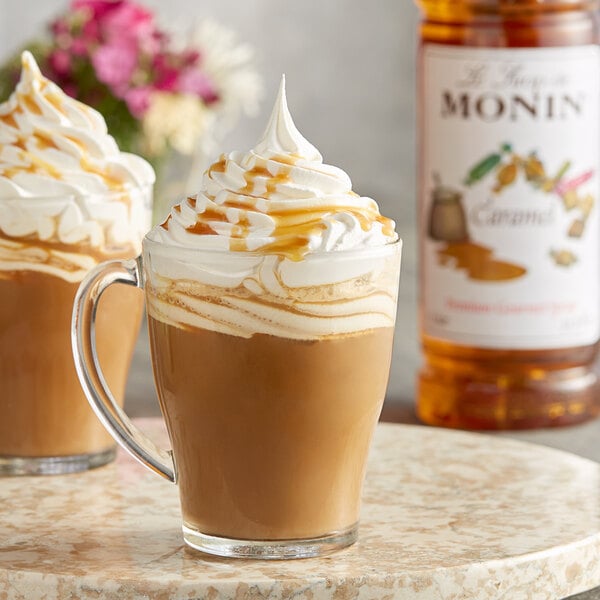 A glass mug of caramel coffee with whipped cream and caramel sauce.