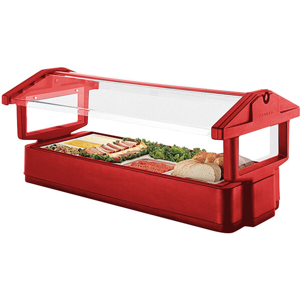 A red food tray in a Cambro table top salad bar with food in it.