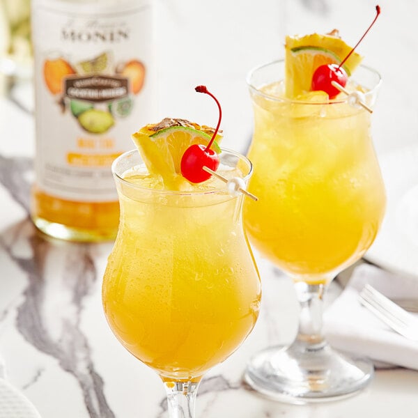 Two glasses of Monin Mai Tai with fruit on top.