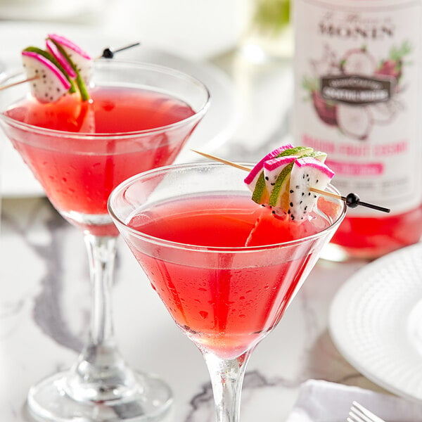 Two Monin Dragon Fruit Cosmo cocktails with lime slices and pink garnish.