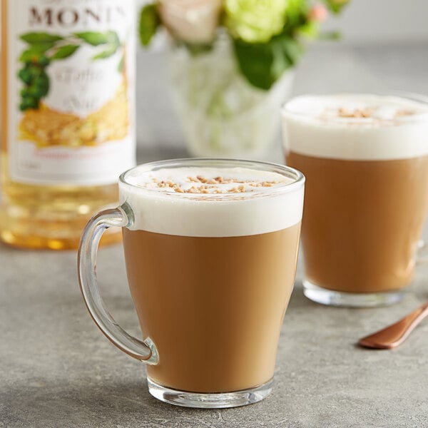 A glass mug with Monin Toffee Nut Flavoring Syrup in brown liquid.