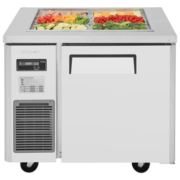 A Turbo Air refrigerated buffet display table with vegetables in it.