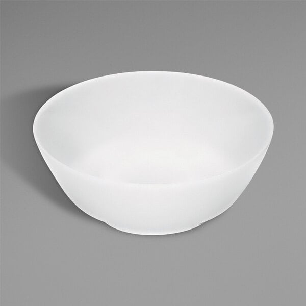 A Bauscher bright white porcelain salad bowl on a gray surface.