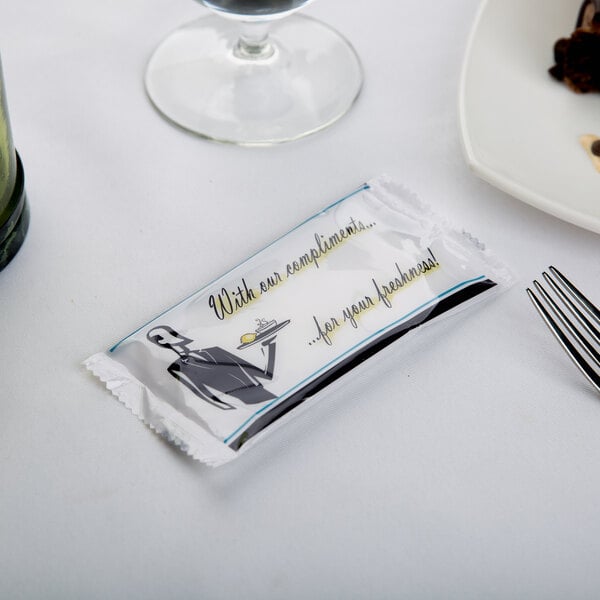 A package of Royal Paper moist towelettes on a table with food.