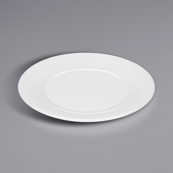 A Bauscher bright white porcelain plate with a wide rim on a gray surface.