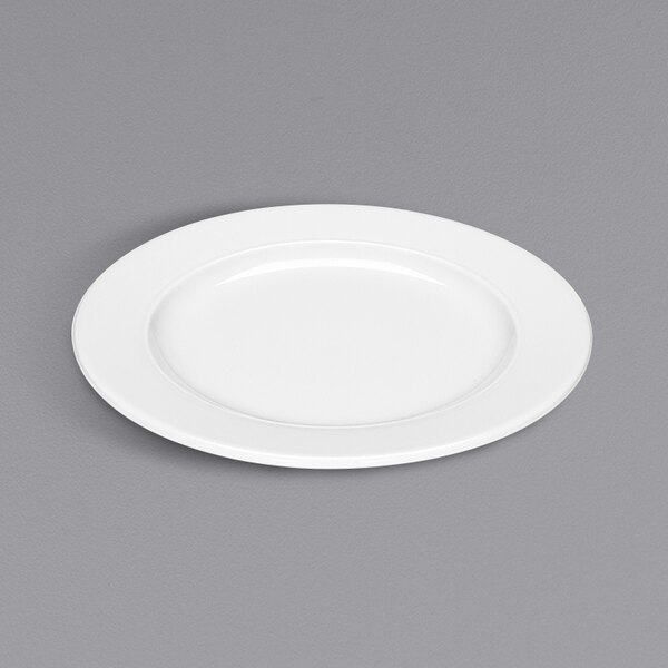 A Bauscher bright white porcelain plate with a wide rim on a gray surface.