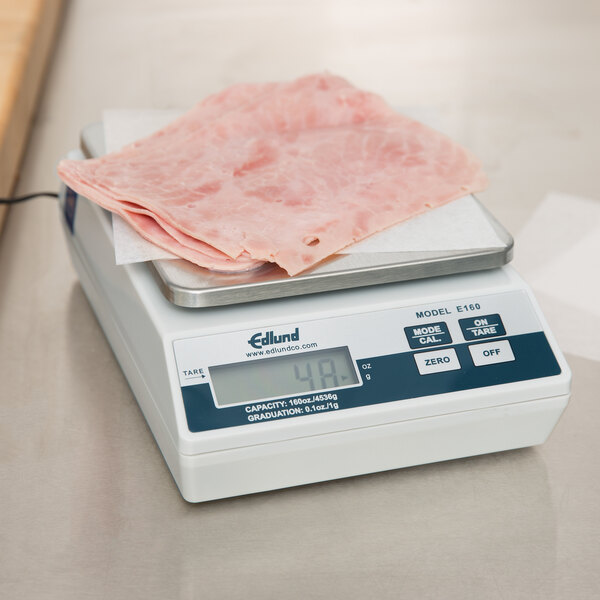 An Edlund digital scale with a piece of meat on it.