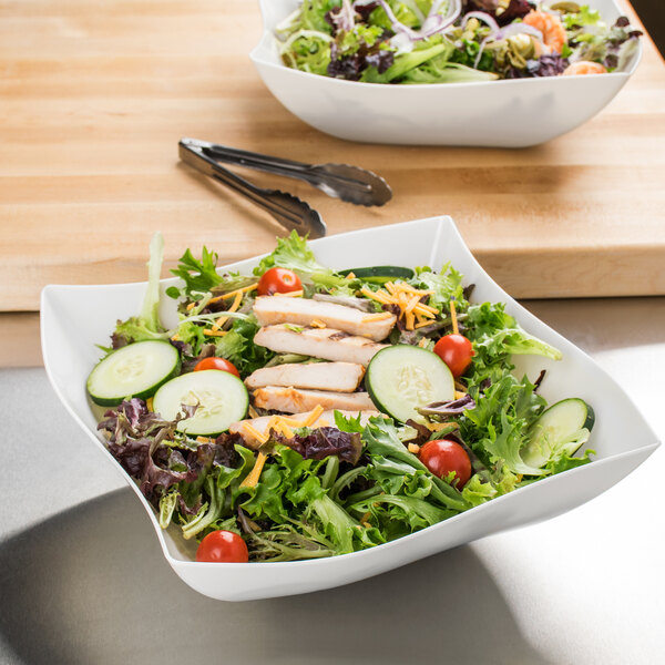 A white Fineline plastic serving bowl filled with salad.