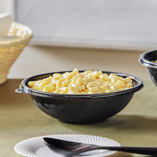 A Visions black plastic bowl filled with macaroni and cheese on a table.