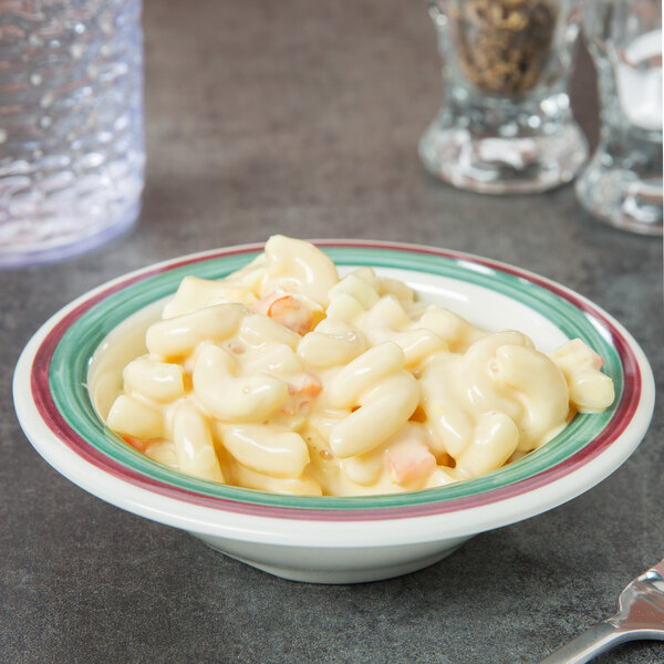 A Diamond Portofino melamine bowl filled with macaroni and cheese with a spoon.