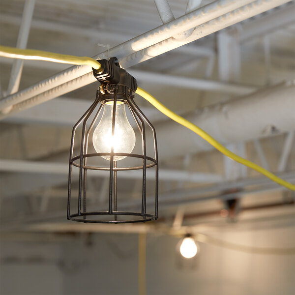 A Voltec work light string with 5 metal cages hanging from a ceiling.