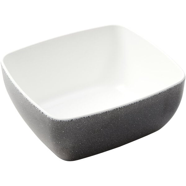 A rectangular white melamine bowl with a black and white speckled surface and white rim.
