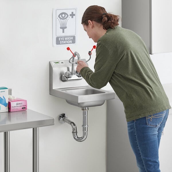 A woman using a Regency wall mounted hand sink.