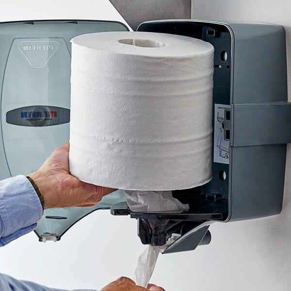 A man holding a Lavex Premium center pull paper towel roll.