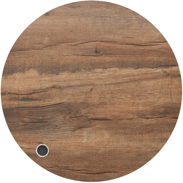 A BFM Seating round knotty pine table top with a metal hole.