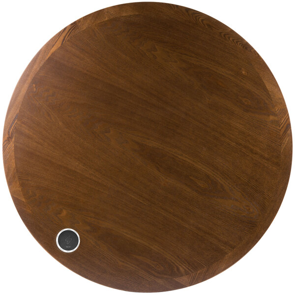A BFM Seating round wooden table top with a wireless charger in the center.