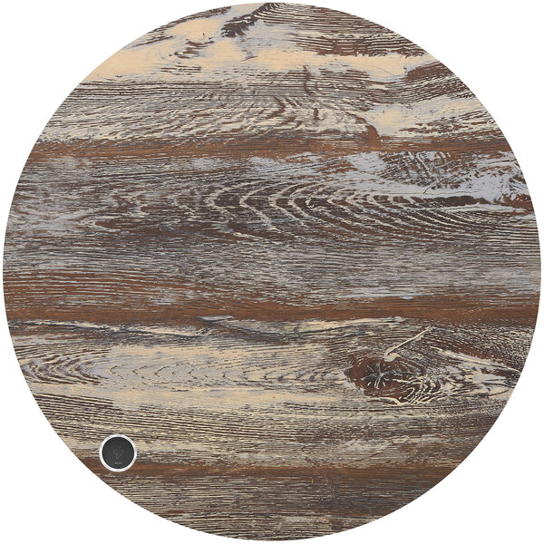 A BFM Seating round wood table top with a brown and white pattern and a black circle with a small black coin.