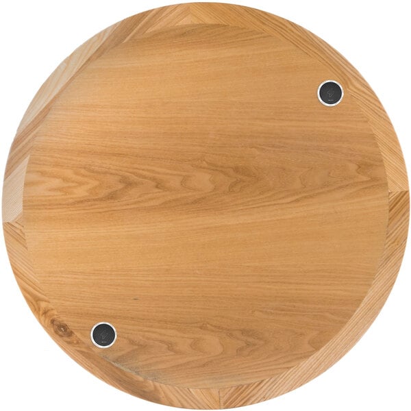 A BFM Seating round natural ash veneer wood table top with two wireless charger holes.