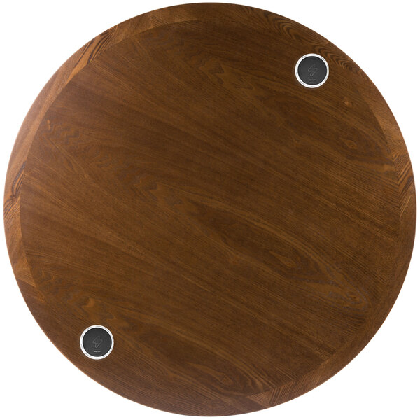 A BFM Seating round wooden table top with two metal circles in it.