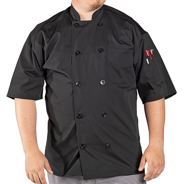 A man wearing a black Uncommon Chef short sleeve chef coat with mesh back.