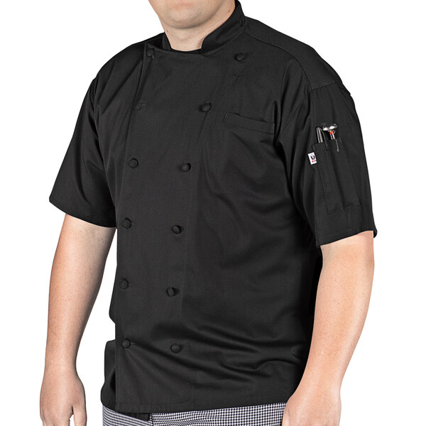 A man wearing a black Uncommon Chef short sleeve chef coat with mesh back.