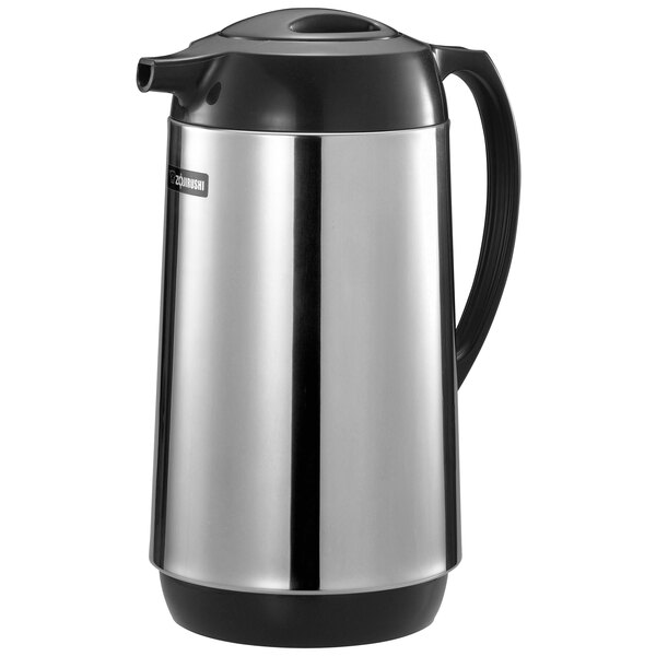 A silver and black stainless steel Zojirushi coffee carafe with a twist-open stopper.