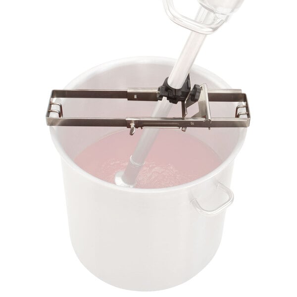 A Robot Coupe immersion blender support for a white pot with a metal handle and a metal pole inside.