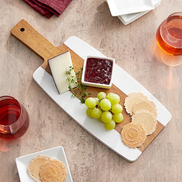 An Acopa acacia wood serving board with cheese and grapes.