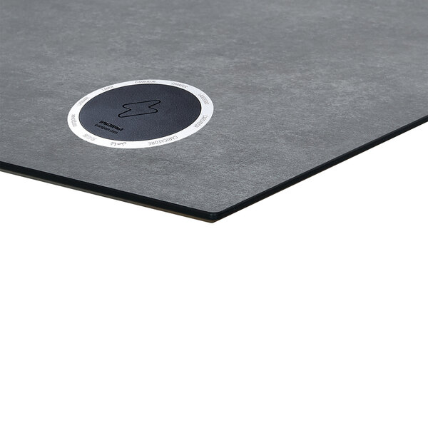 A grey rectangular table top with a black wireless charger.