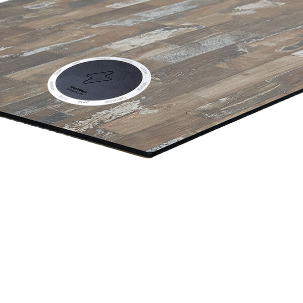A BFM Seating round planked pine composite laminate table top with a wireless charger.