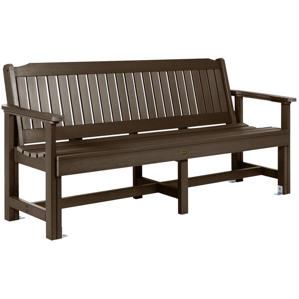 A brown wooden bench with slatted armrests.