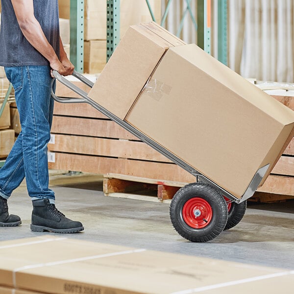 A man pushing a Lavex hand truck with a box.