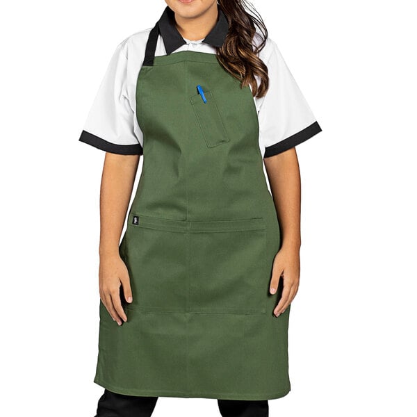 A woman wearing a Uncommon Chef sea green bib apron with black webbing.