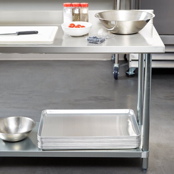 A Regency stainless steel work table with bowls on a galvanized undershelf.