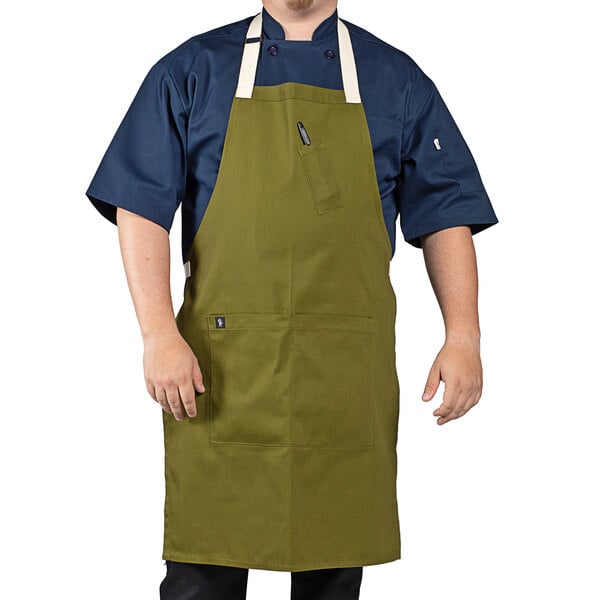 A man wearing a moss green Uncommon Chef bib apron with natural webbing.