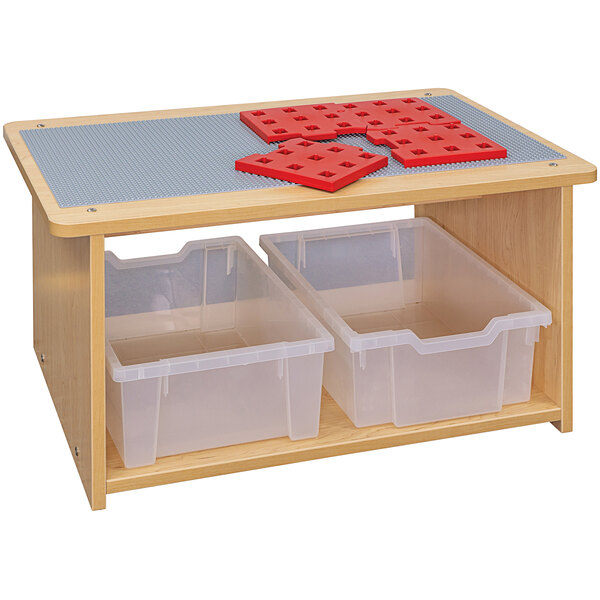 A Tot Mate maple laminate toddler play center with plastic bins on a wooden table.