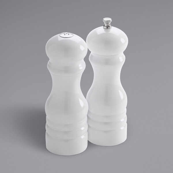 Two white wooden salt and pepper shakers.