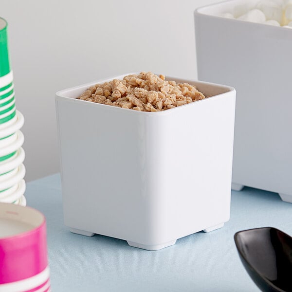 An American Metalcraft white square melamine jar with food inside.