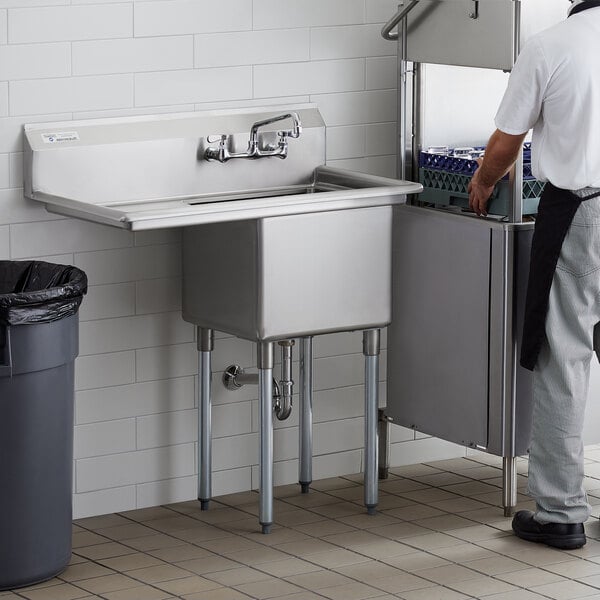 A man standing next to a Steelton stainless steel commercial sink with left drainboard.