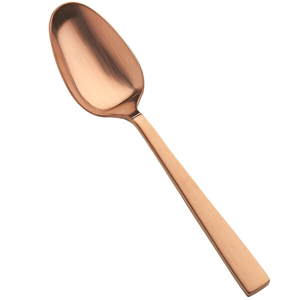 A close-up of a Bon Chef Roman Matte Rose Gold serving spoon with a copper finish.