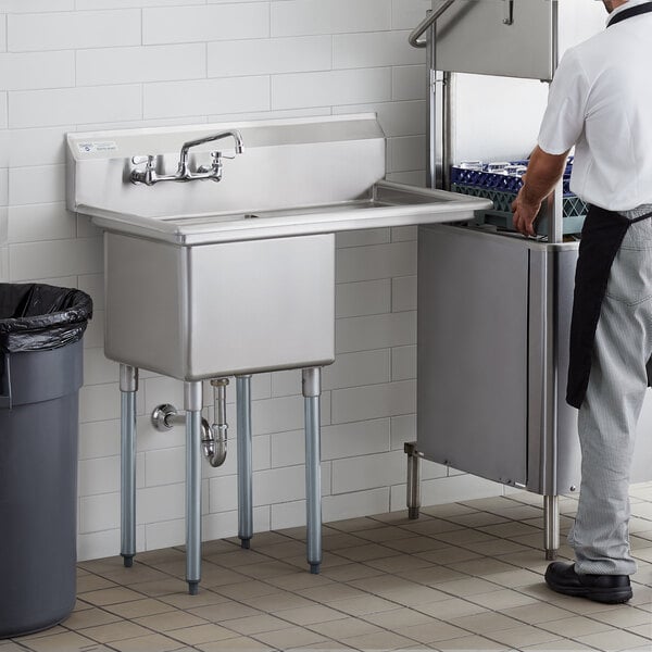 A man standing next to a Steelton stainless steel commercial sink with right drainboard.