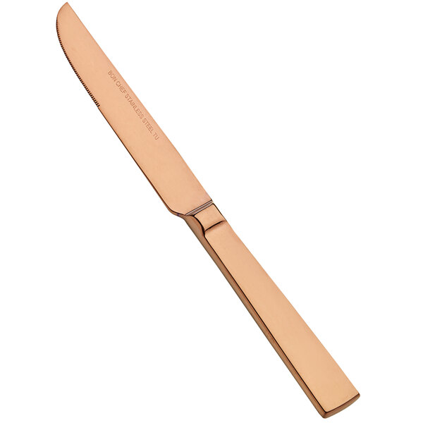 A Bon Chef stainless steel dinner knife with a rose gold handle on a counter.