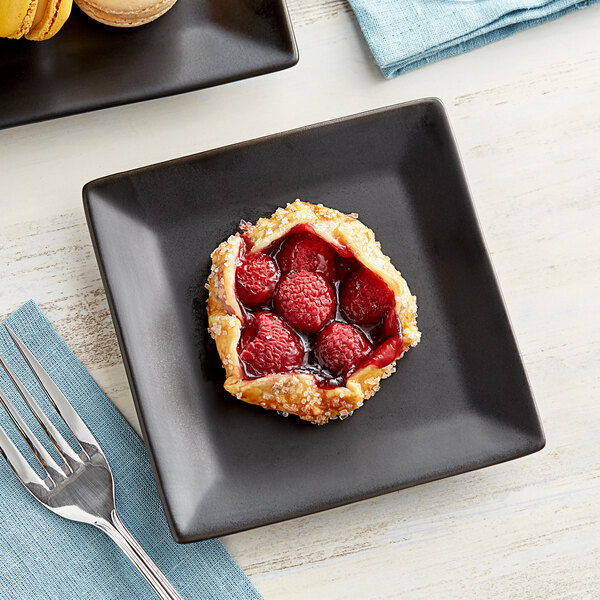 A black Acopa stoneware plate with raspberry pie on it.