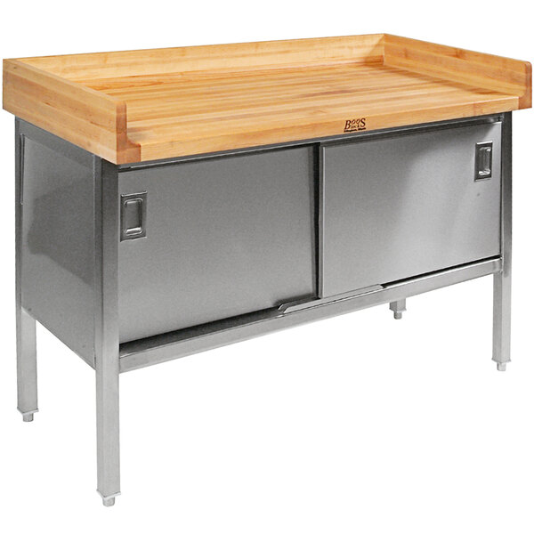 A large wood and stainless steel baker's table with sliding doors on a stainless steel base.
