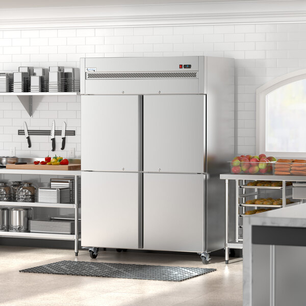 An Avantco stainless steel reach-in freezer with half doors in a large kitchen.