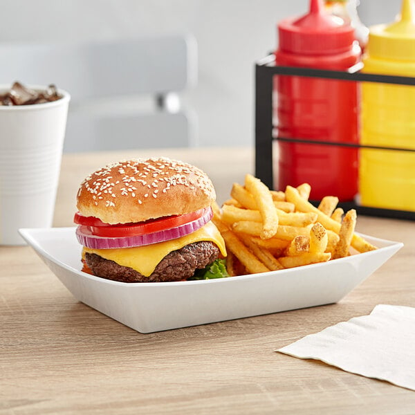 A cheeseburger and fries in a Tablecraft white rectangular serving basket.