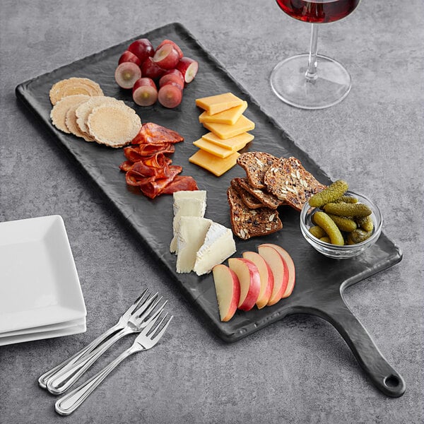 A Tablecraft rectangular faux slate melamine serving paddle with a plate of food and a glass of red wine on a table.