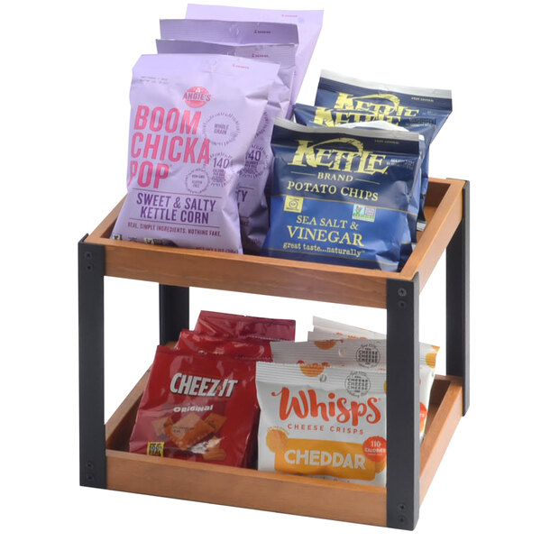 A Cal-Mil Madera wood merchandiser with two shelves of snacks, including a variety of chips.