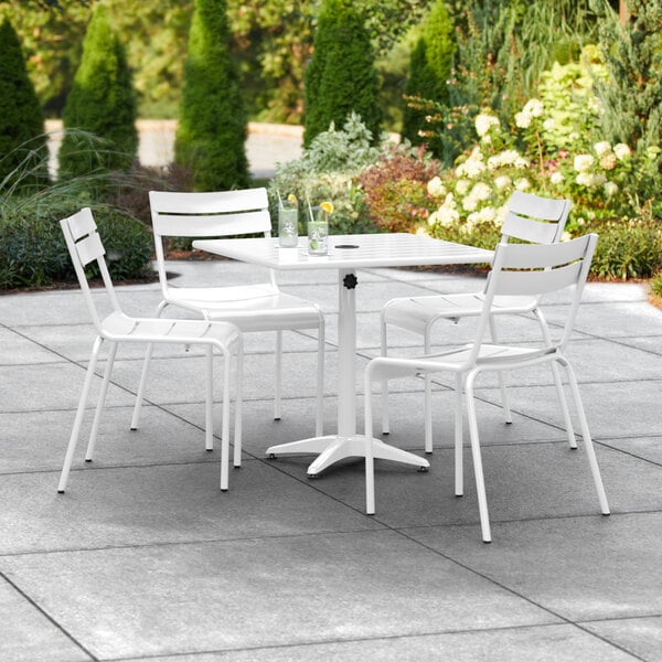 A white table and chairs on a patio.