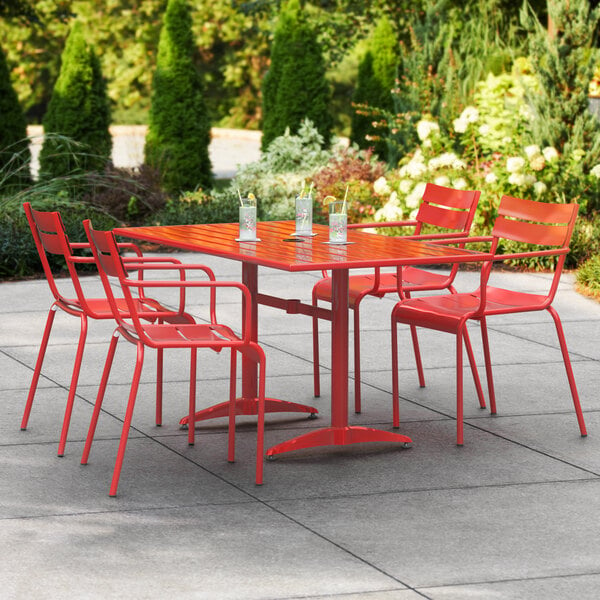 A red Lancaster Table & Seating outdoor dining set with four chairs on a patio.